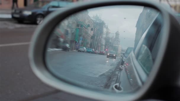 Silnici odráží v zrcadle auto, večerní ulice s budovami a stěhování automobilů. Auto s světla při otáčení