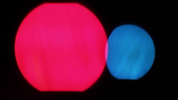 Twee grote bokeh lichten samen-rood en blauw op zwarte achtergrond — Stockvideo