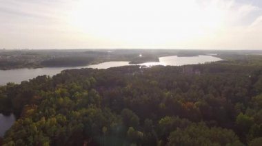 4 k hava manzara - uçuş Nehri Vadisi evleri ve orman yakınındaki ile üzerinden. Yeşil orman ve bir kasaba çevrili bir nehir alan helikopter çekim