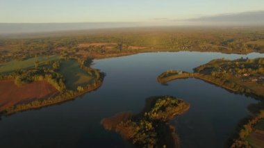 4 k havadan görünümü - göl ve ülke alanındaki hasat alanlar günbatımı ışığı - sonbahar manzara