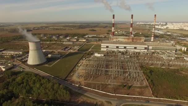 Prise de vue aérienne 4K - survol d'une centrale électrique avec des tuyaux fumeur et d'une ville proche - vue industrielle — Video