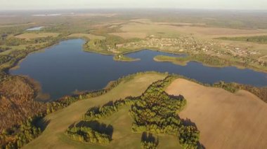 4 k havadan görünümü - güzel mavi göl ve güneşli havalarda kırsalında hasat alanları üzerinde uçan - sonbahar renkleri