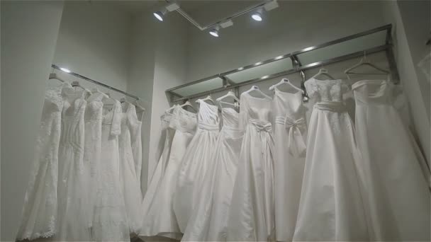 Vestidos de noiva em boutique nupcial. Balas panorâmicas — Vídeo de Stock