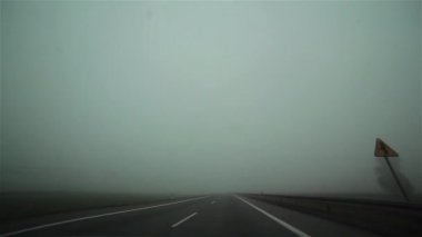 Arabalar ve kamyonlar pencere cam onboard fotoğraf makinesinden görülen sisli bir yolda bir araba