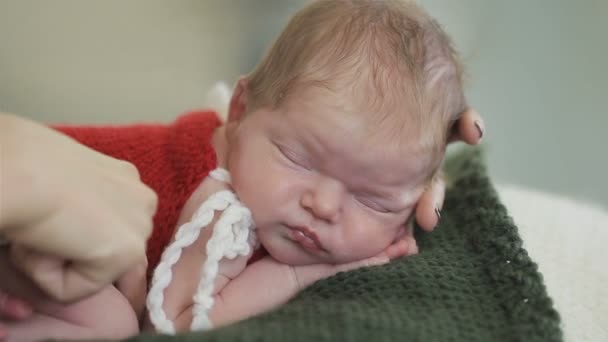 Female hands carefully arrange sleeping baby ready for shooting. Close up — Stock Video