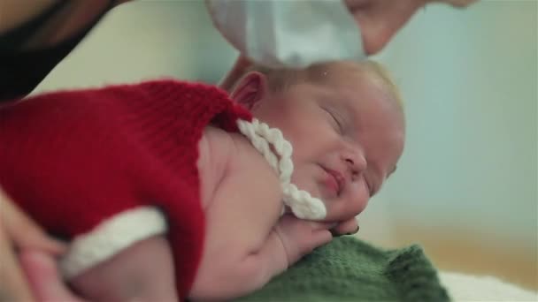 As mãos femininas cuidadosamente vestem-se e arranjam o bebê adormecido pronto para atirar. Fechar — Vídeo de Stock