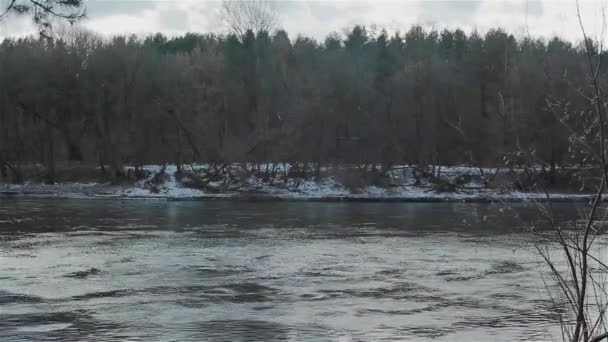 La orilla de un río que fluye rápido. Paisaje invierno — Vídeos de Stock