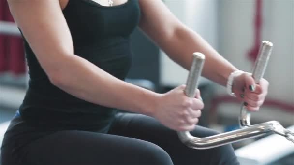 Mujer joven entrenando en máquina de remo en el gimnasio. Primer plano — Vídeo de stock