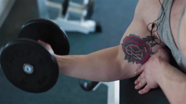 Primer plano de un brazo de atletas jóvenes haciendo ejercicio con pesas — Vídeos de Stock