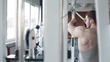 Spor salonunda egzersiz genç bir vücut geliştirmeci arkadan görünüm