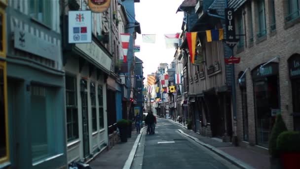 HONFLEUR, FRANCIA - 19 DE NOVIEMBRE DE 2014: Gente caminando por la calle peatonal de la pequeña ciudad europea de Honfleur, en el norte de la región de Baja Normandía, situada en el estuario donde el río Sena se encuentra con el Canal de la Mancha, famoso destino turístico — Vídeo de stock