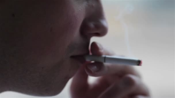 Zblízka na mladého muže, který kouří cigaretu — Stock video