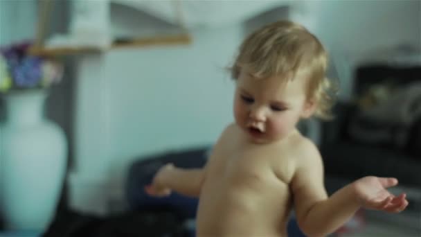 Nahaufnahme von entzückenden niedlichen kleinen Jungen, die Hände klatschen und mit Emotionen reagieren, die in einem Raum stehen — Stockvideo
