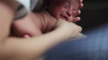 Umutsuzca ağlayan küçük yeni doğan bebeğin yakın çekim. Hemşire bir maskeli acınası yorgun yalan ve çığlık bebek çocuk sakinleştirmeye çalışıyor
