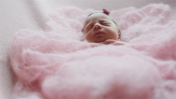 Gros plan de belle petite fille nouveau-née dormant couverte d'une couverture tricotée rose clair — Video