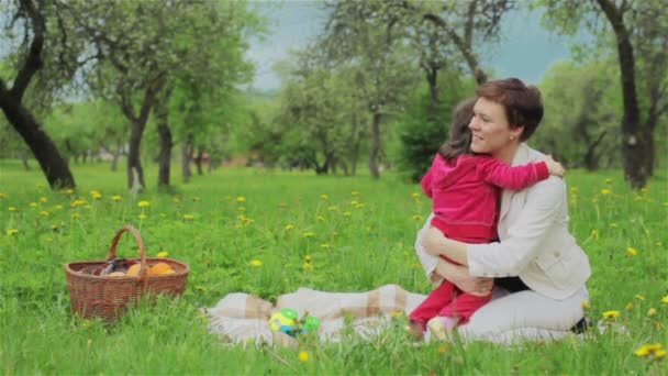 Uma menina a abraçar a mãe. Piquenique de verão — Vídeo de Stock