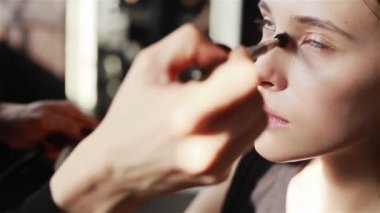 Profesyonel makyaj sanatçısı Vakfı bir fırça ile uygulama, cilde yüz modelleri. Yakın çekim