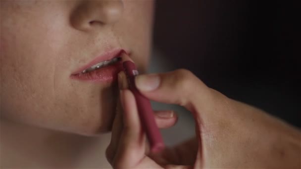Profesyonel makyaj sanatçısı çalışma. Kontur model dudaklar için uygulanıyor. Dudak parlatıcısı model dudaklar için uygulanıyor. Bir fırça bir makyaj kullanarak. Yakın çekim — Stok video