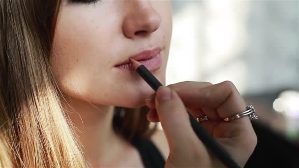 Nahaufnahme eines professionellen Visagisten, der Kontur auf die Lippen aufträgt — Stockvideo