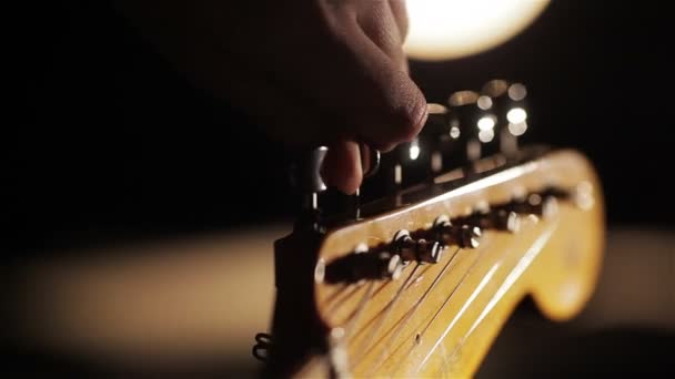 Macro close-up van vingers tuning gitaar pinnen — Stockvideo