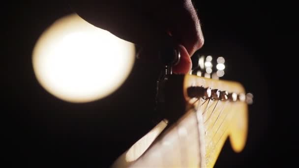 Macro primer plano de dedos rodando clavijas de una afinación de guitarra — Vídeo de stock