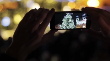 Akıllı holding eller ışıklı geleneksel Noel ağacı ve katedral eski şehir Meydanı Prag, Çek Cumhuriyeti için at filme telefon. Avrupa'nın Noel