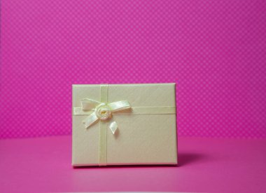 Pembe arkaplanda küçük hediye kutusu
