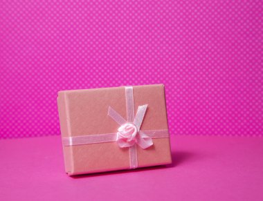 Pembe arkaplanda küçük hediye kutusu
