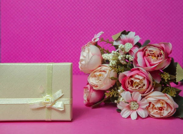 present box with flowers on pink background