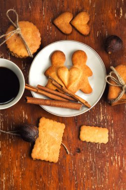 Kalpleri ve kahverengi ahşap doku arka plan ışık plakalı bir kahve parlak kadar yanında kenevir tarafından bağlanmış erkek şeklinde kurabiye