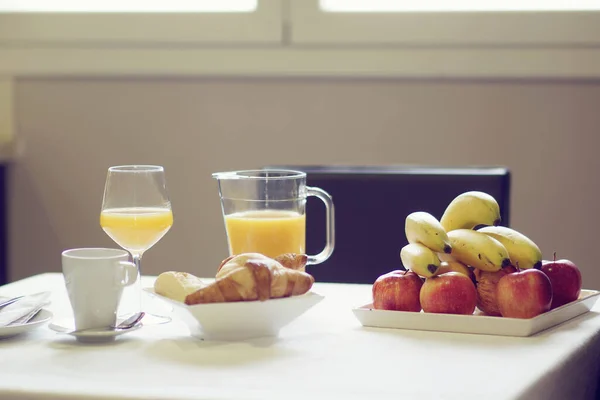 Taze meyve ve biraz kruvasanla birlikte doğal portakal suyundan oluşan sağlıklı bir kahvaltı.