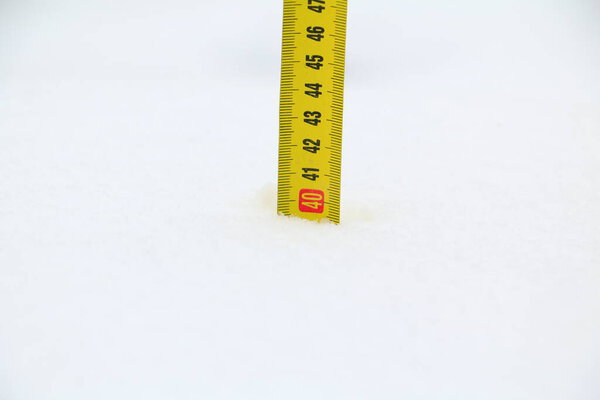 метр, маркирующий накопленный снег. метр, вставленный в снег для измерения накопленного снега. Шторм Филомена оставляет полметра снега в Мадриде