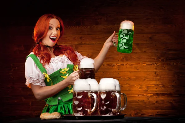 Mulher bávara com cinco copos de cerveja marrom e uma cerveja verde G — Fotografia de Stock