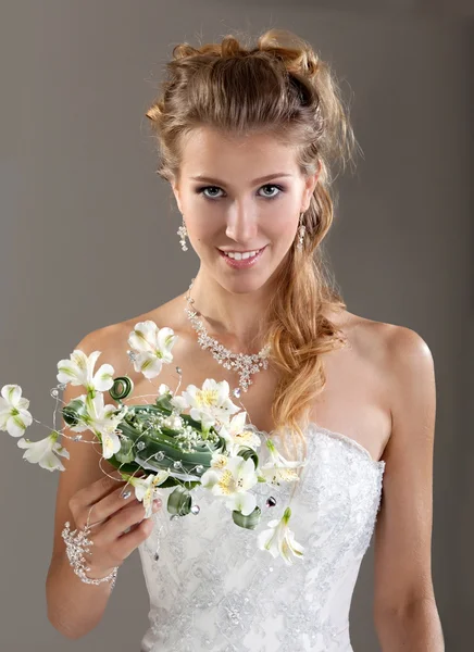 Beautiful smiling bride in the veil with bouquet. Gray Backgroun — Stock Photo, Image