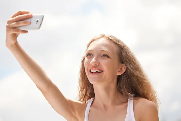 Mulher bonita adolescente tomando um selfie com telefone — Fotografia de Stock