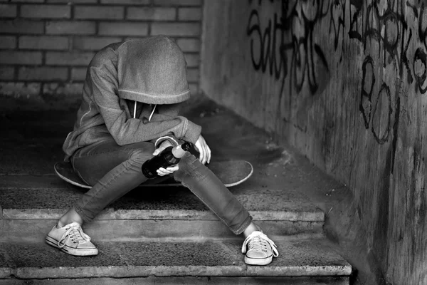 Adolescente tenant une bouteille de bière et assis sur les marches — Photo