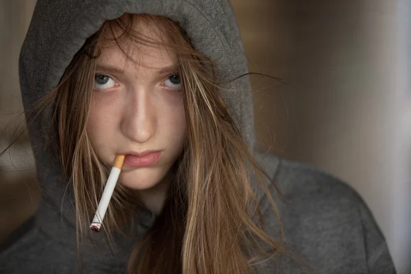 Teen κορίτσι στην κουκούλα που καπνίζει ένα τσιγάρο — Φωτογραφία Αρχείου