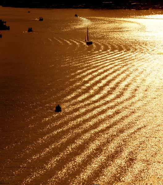 Silhuetas de pequenos barcos no rio nos raios do setti — Fotografia de Stock