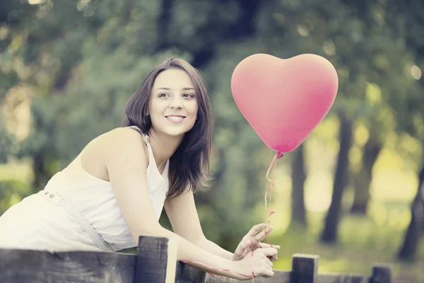 Happy Smiling Young Woman with a Red Shaped Heart Balloon Royalty Free Stock Photos