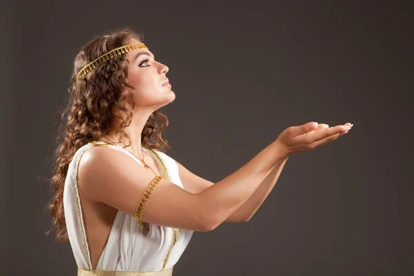 Klassische griechische Göttin in Tunika, die etwas auf ihren Händen trägt — Stockfoto