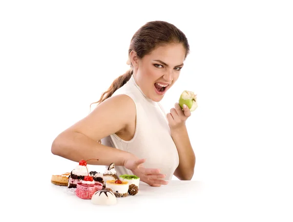 Young beautiful women eating apple and refusing cookies — Stock Photo, Image