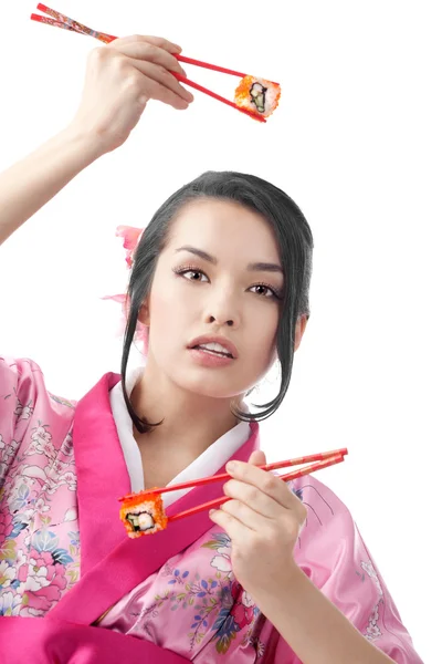 Krásná žena, držící Sushi se dvěma páry hůlky — Stock fotografie