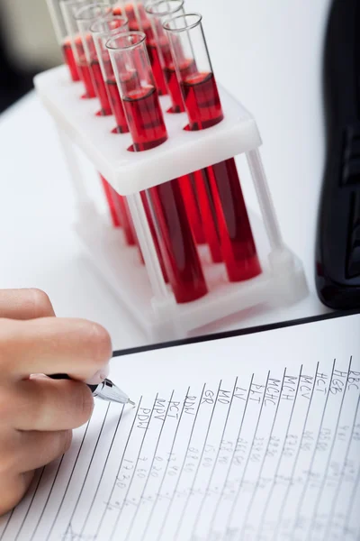 Doctor's medical notes and blood samples — Stock Photo, Image