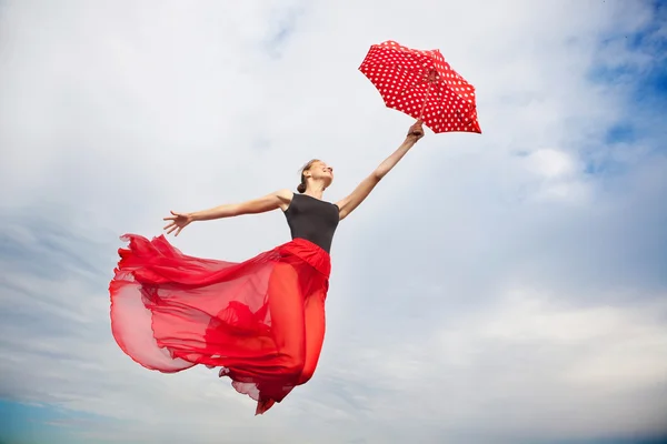 Mujer joven volando en el cielo con paraguas — Foto de Stock