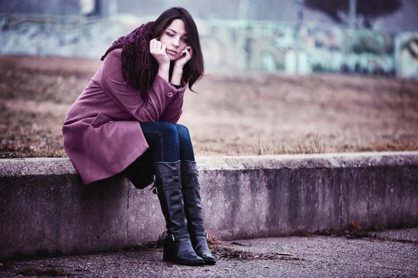 Triste jovem mulher sentada ao ar livre — Fotografia de Stock