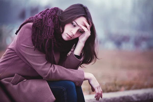 Triste joven sentada al aire libre —  Fotos de Stock