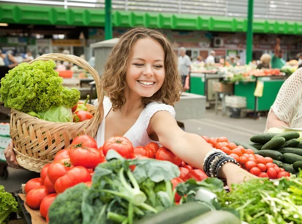 Jovem mulher comprando legumes na mercearia — Fotografia de Stock