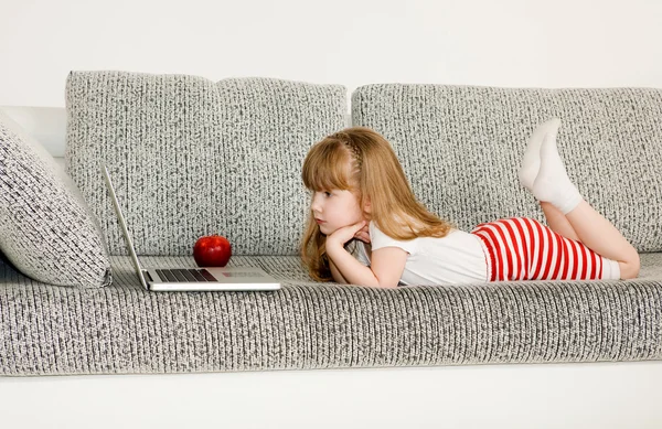 Bambina che gioca con il computer portatile — Foto Stock