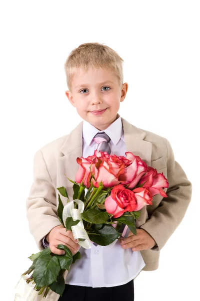 Schattige kleine gentleman permanent met grote boeket van rode rozen — Stockfoto