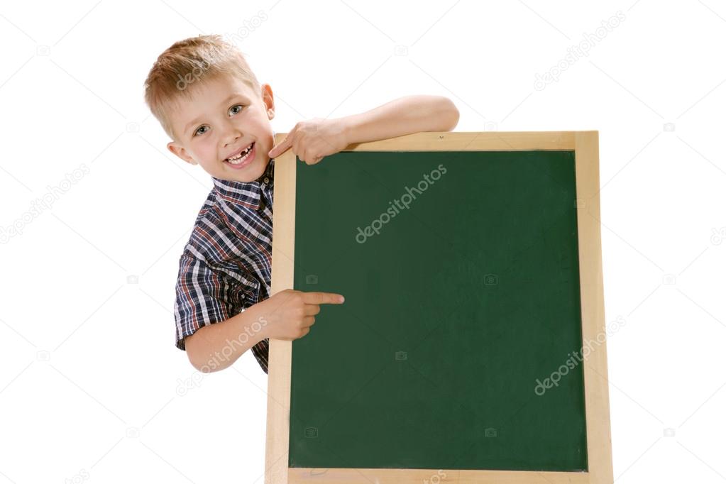 Smiling little boy pointing a sign at the school blackboard